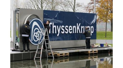 Electricians carry a cover with the logo of ThyssenKrupp AG at the company's headquarters in the western German city of Essen